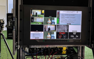 Streaming-Regie im Flightcase mit Mehrfachansicht, dahinter Trainer vor der Kamera – Aufzeichnung für den BDFL in Bad Aibling