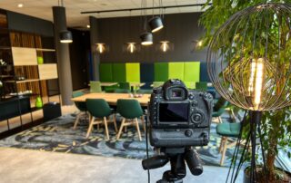 Work Café mit grünen Polstern und Kamera auf Stativ – Fotoshooting bei Avnet für office4you