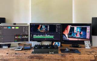 Neue Workstation mit drei Monitoren, Grading-Panel und Lautsprechern auf der Holzwerkbank