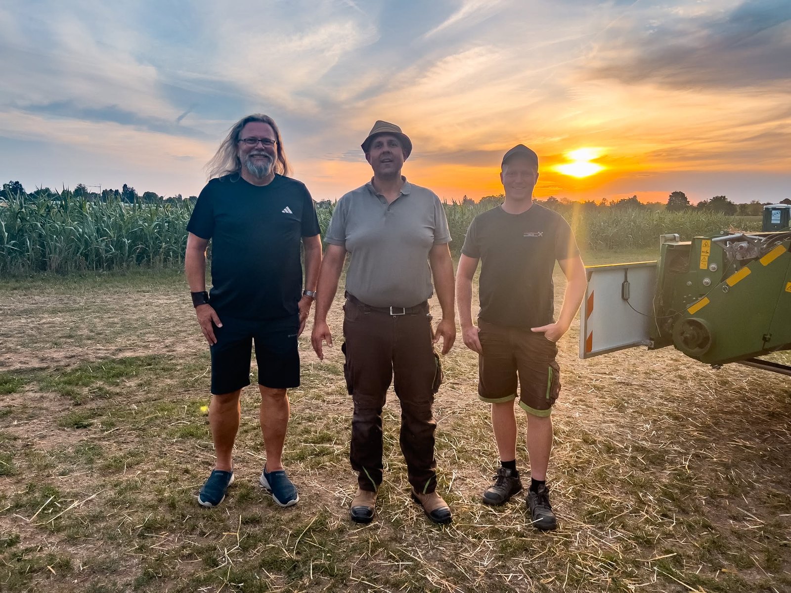 Mike, Roland Habeker und Team im Abendlicht auf dem Feld