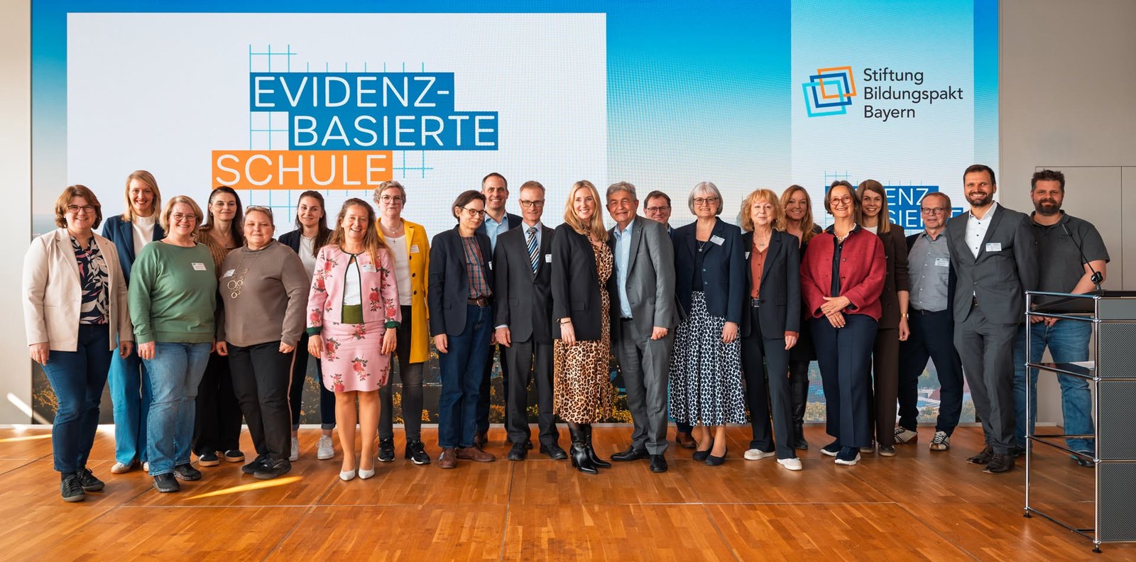 Gruppenbild der Beteiligten vor der Leinwand