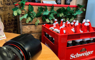 Kasten Schweiger mit Weihnachtsmützen auf den Flaschen am Messestand – Fotoshooting auf der Food & Life München