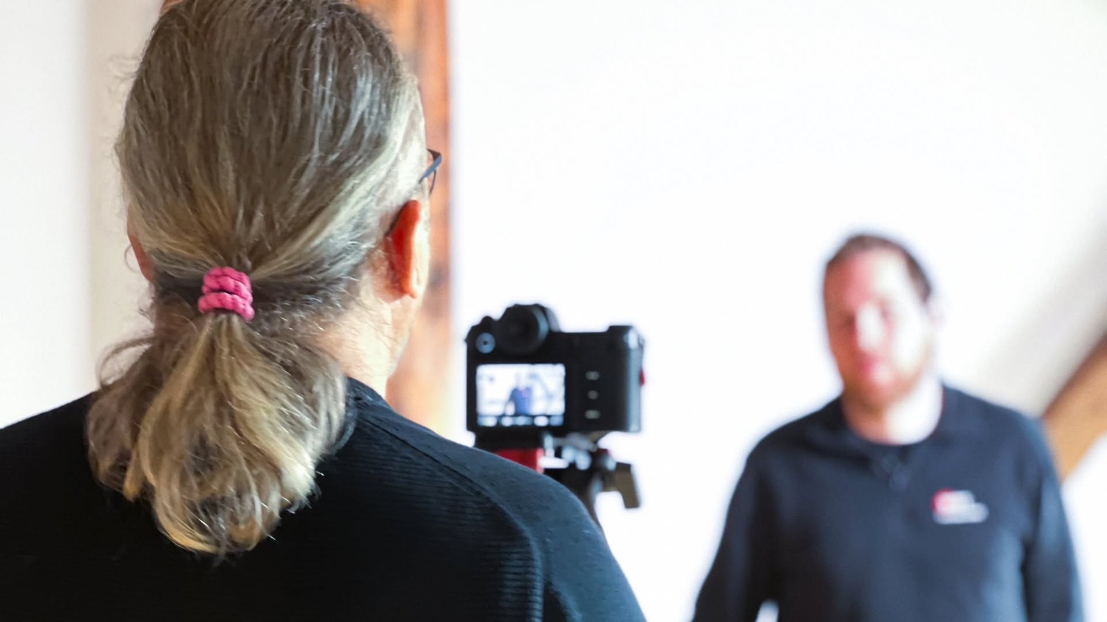 Blick über die Schulter auf den Kameramonitor beim Interview