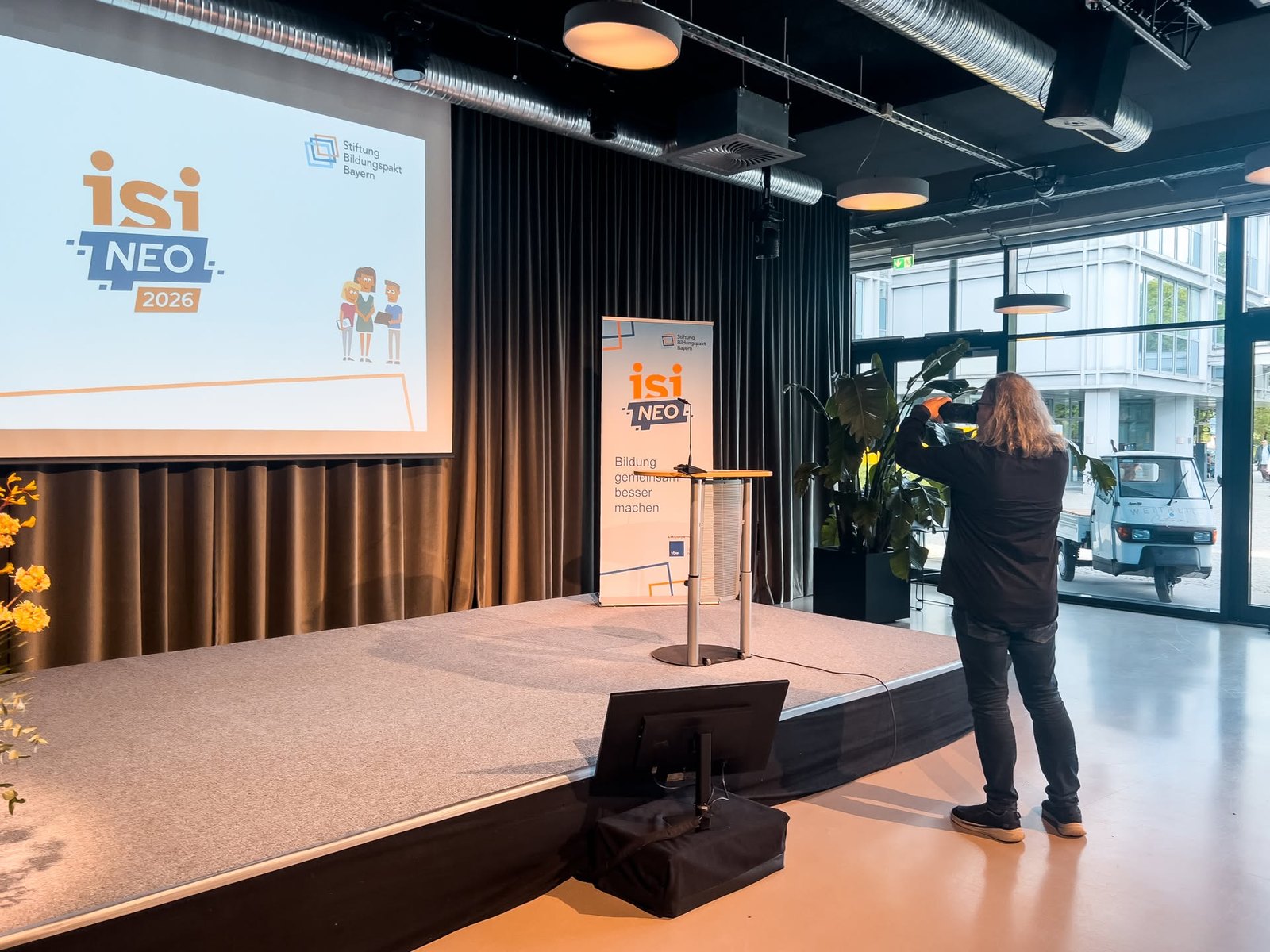 Der Saal vor der Veranstaltung mit Leinwand und Bühne