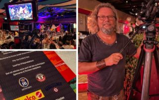 Michael J. Müller mit Kamera beim Night-Wiesn-Anstich 2021, daneben Monitor und Programmkarte