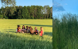 Fotograf im hohen Gras, im Hintergrund die Dirndl der Wuidn Bixn auf der Wiese – Shooting für die Privatbrauerei Schweiger