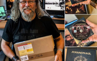 Michael J. Müller mit Paket und der Schandmaul-Fanbox „Artus“, daneben DVD und CD