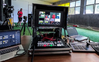 Streaming-Studio im Flightcase mit ATEM-Bildmischer und Monitor in einer Sporthalle – „Studio in a box“