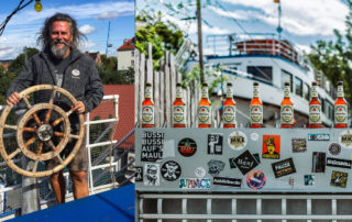 Michael J. Müller mit Steuerrad und Flaschen Schweiger Naturradler auf der Alten Utting in München