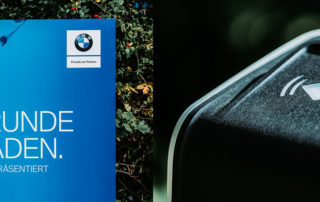 Schild „Eine Runde aufladen“ von BMW und Ladestation – Fotoshooting für die Wallstein Gruppe am Golfclub München-Riedhof