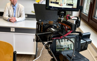 Kamera mit Monitor filmt einen Mann im Klassenzimmer – Projekt „Wirkstatt Nachhaltigkeit“