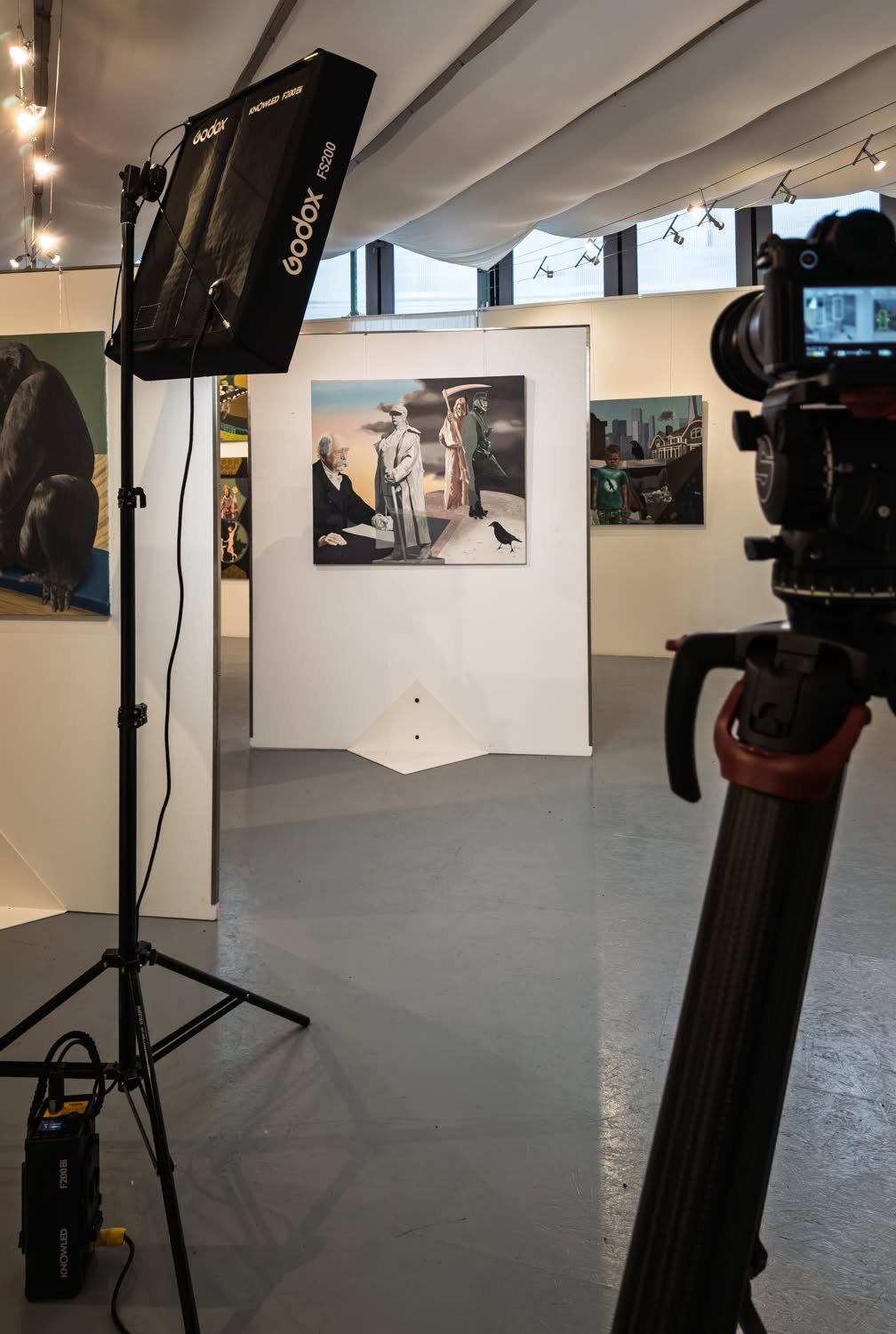 Kamera und Leuchte auf Stativen im Ausstellungsraum